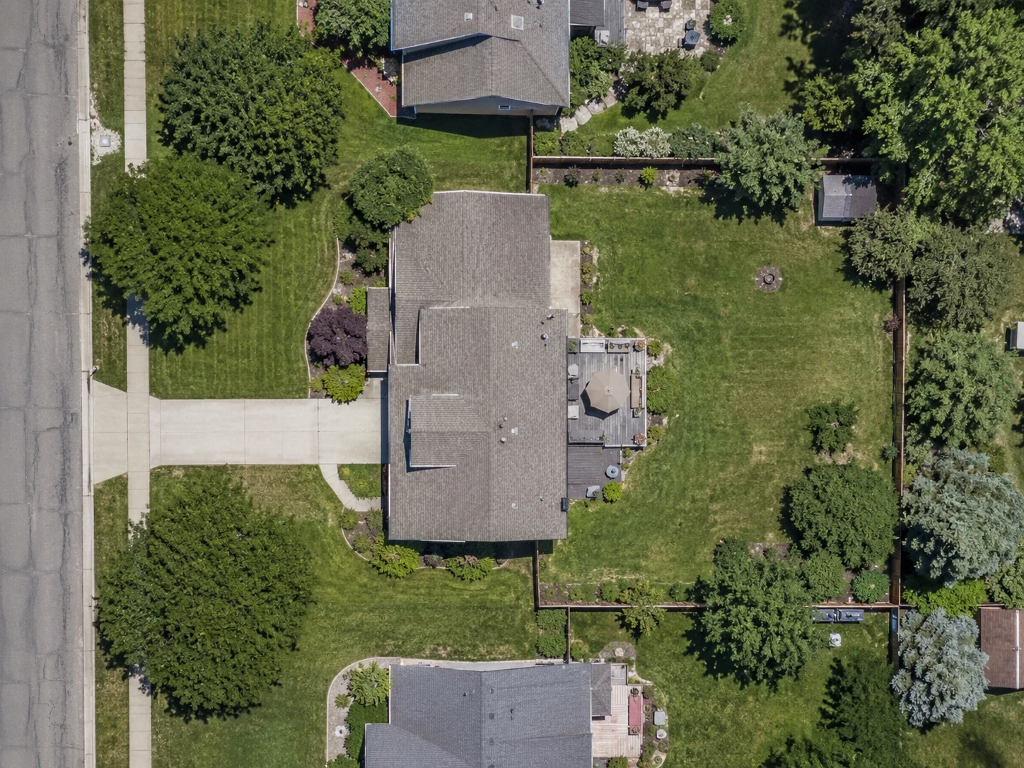 The same aerial photograph in a shaded capture, where the shade cast by the street trees closes up along the driveway and front yard and the edges under it cannot be made out.