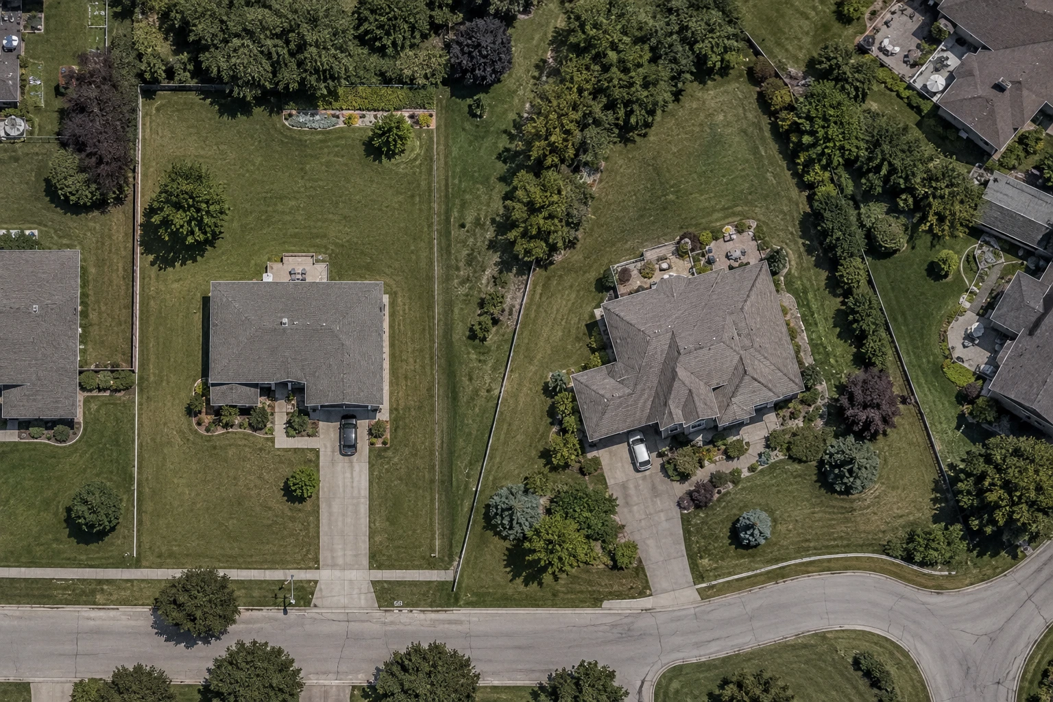 Aerial comparison of two neighbouring residential lots, both traced: a rectangular lot with four corners, and an irregular corner lot whose frontage follows the curve of the road and whose rear boundary tapers.
