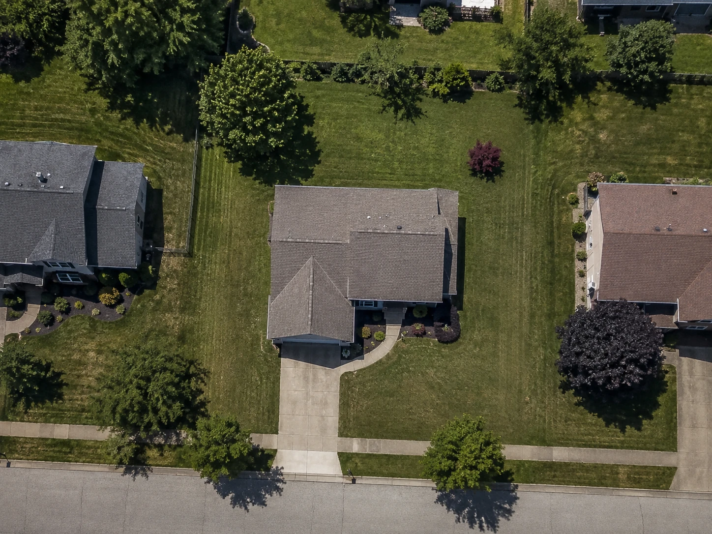 An aerial view of a residential property with the lawn traced and measured at 9,840 square feet. The traced outline surrounds the grass on all four sides of the house and leaves out the house itself, the driveway and the walkway to the front door.