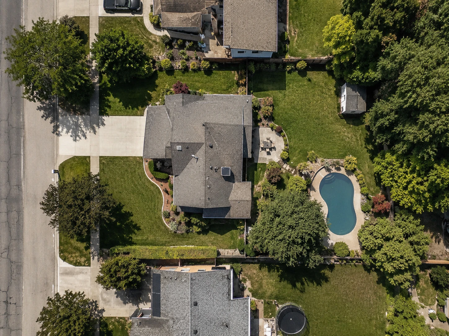 An aerial view of a residential property with the whole lot traced and measured at 12,460 square feet, or 0.29 acres. The house, driveway, pool, shed, trees and lawn all sit inside the traced boundary.