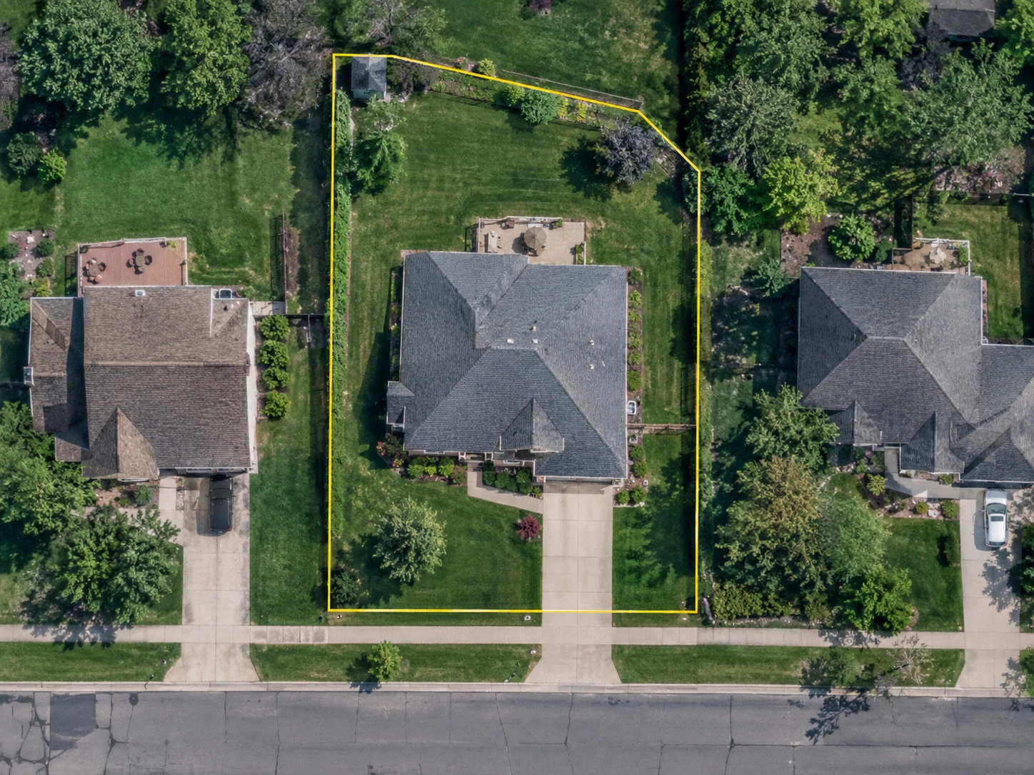 Satellite view of a residential property with its parcel boundary outlined in yellow.